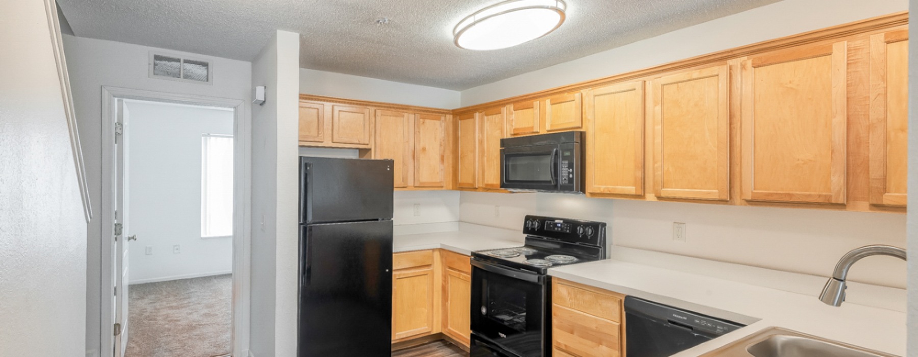Apartment kitchen with white walls and black appliances