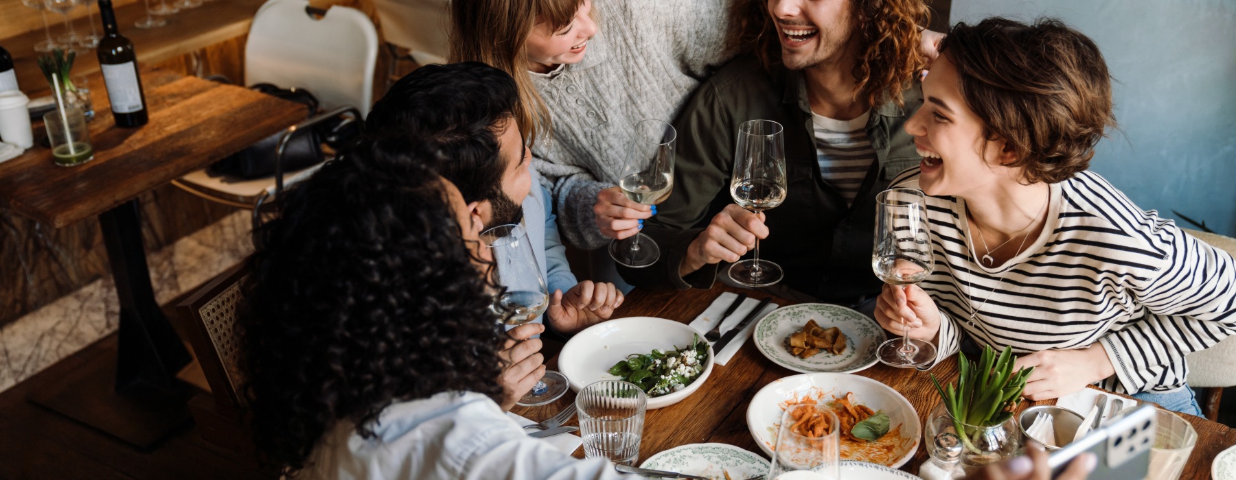 Friends laughing around a table with food