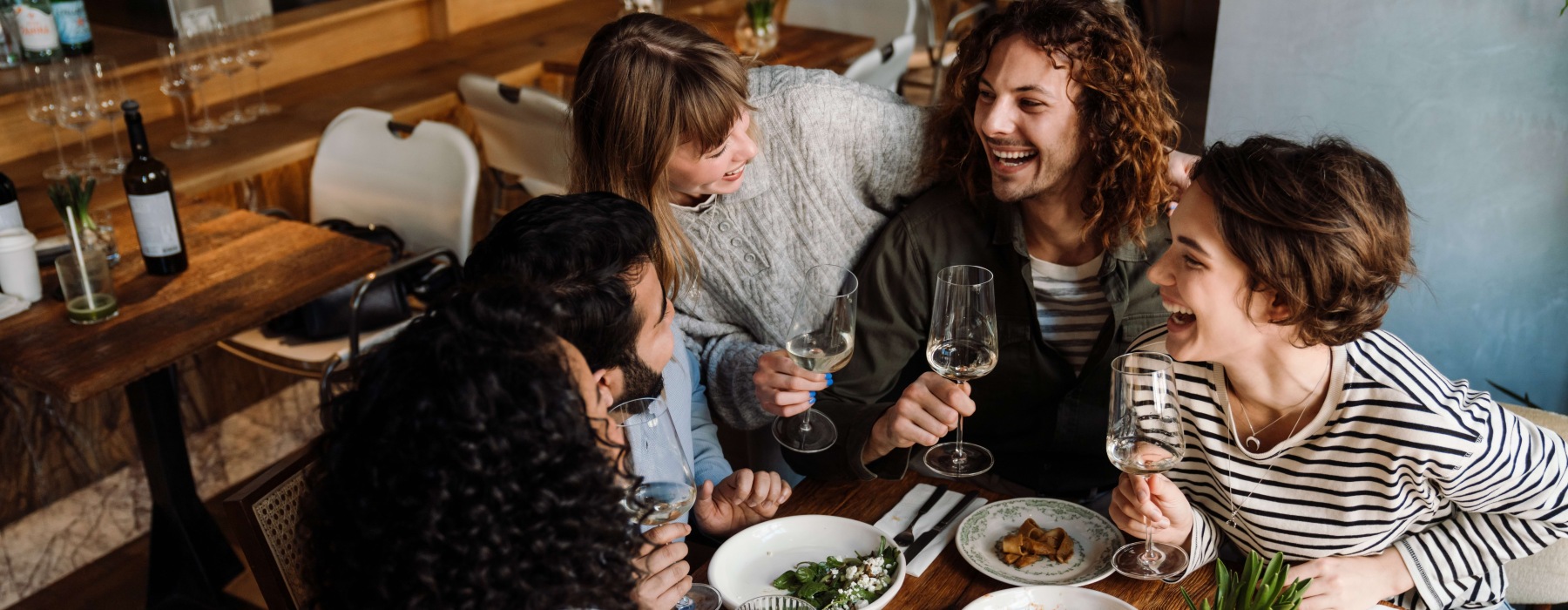 Friends laughing around a table with food